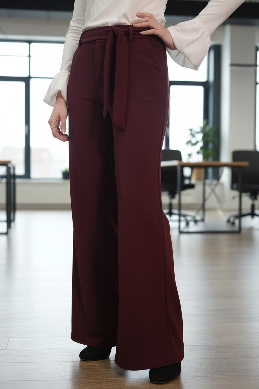 Pantaloni office evazați de damă cu cordon, bordo – vedere din față, cu mâna pe șold
